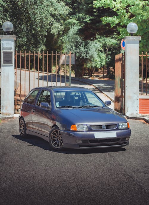 Blue Car Parked Near an Iron Gate