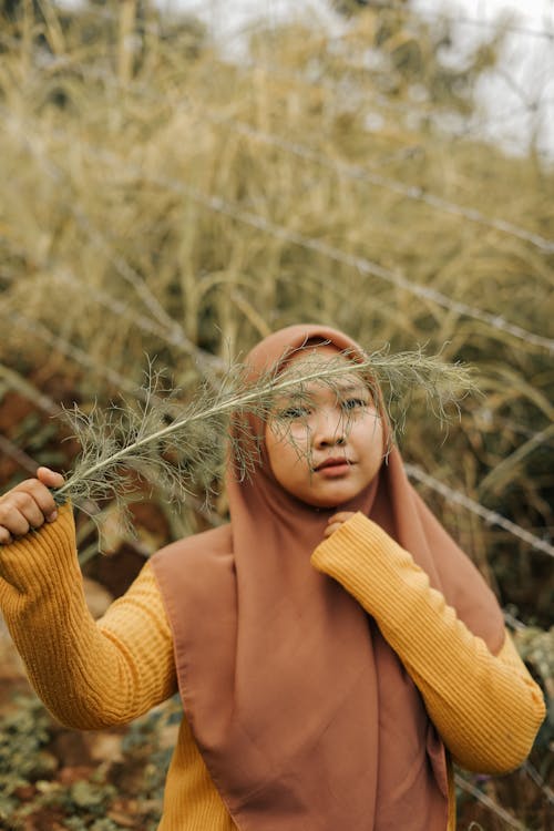 Woman in Yellow Long Sleeve Shirt Wearing Brown Hijab