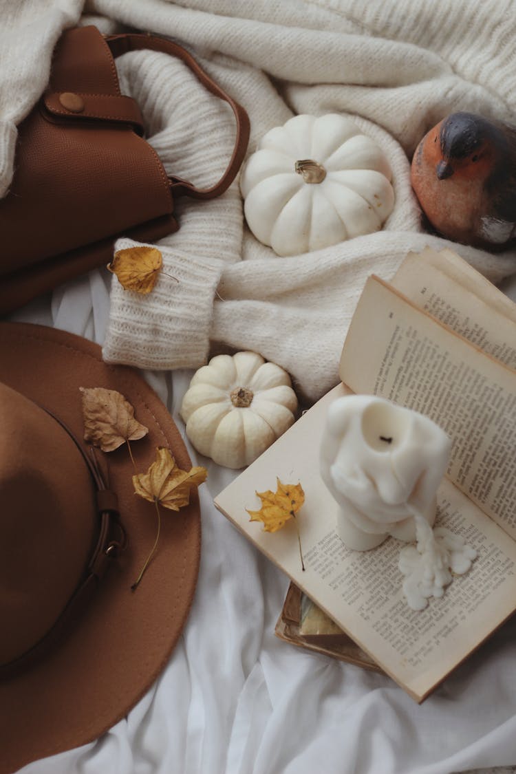 Close Up View Of Autumn Leaves, Brown Hat And Bag, Book And Candles