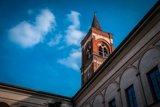 一座砖砌的钟塔映衬在充满活力的蓝天下，展现出经典的建筑细节