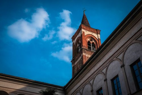 Free A brick tower with clock against a vibrant blue sky, showcasing classic architectural details. Stock Photo