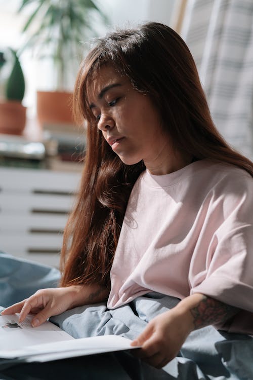 Free Woman with dwarfism reading in bed Stock Photo