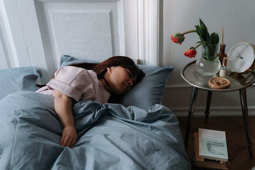 Woman with dwarfism sleeping in bed