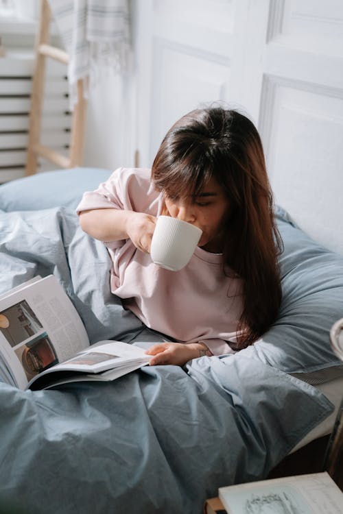 Free Woman with dwarfism drinking coffee in bed Stock Photo