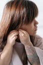 Girl with dwarfism putting on earring