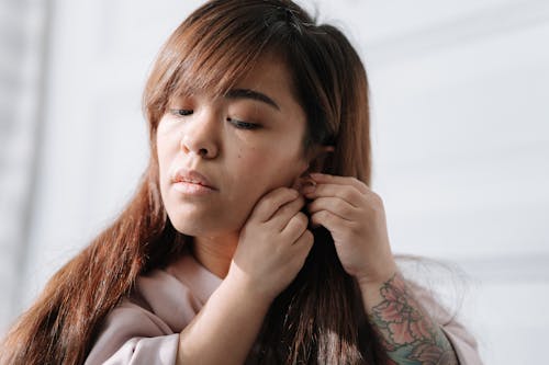 Woman putting on earrings