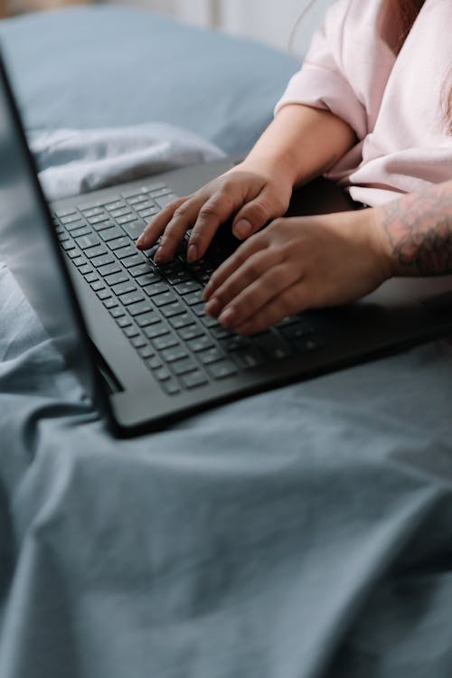 Free Woman working on a laptop in a bed Stock Photo