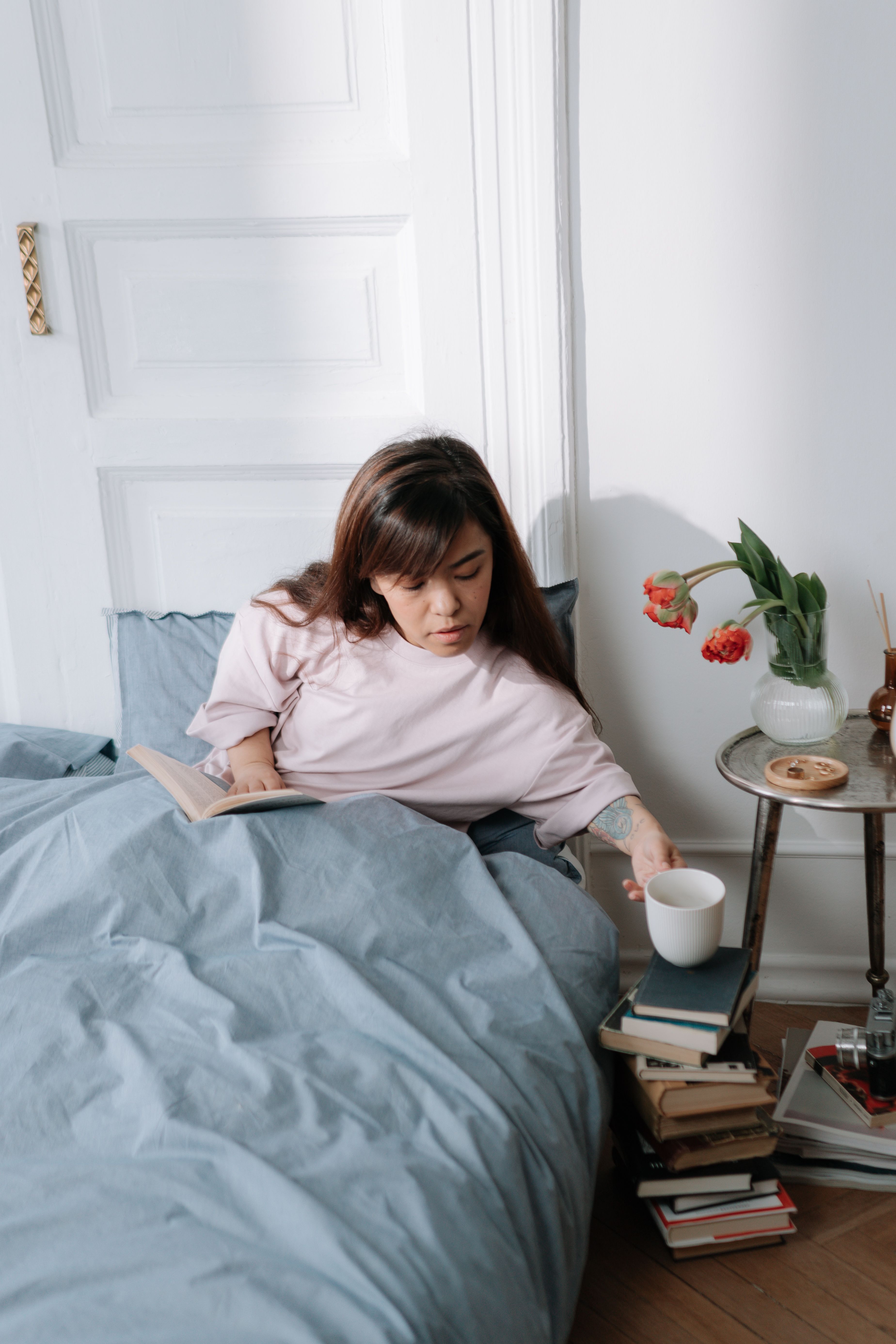 Woman sitting in a bed reading a book