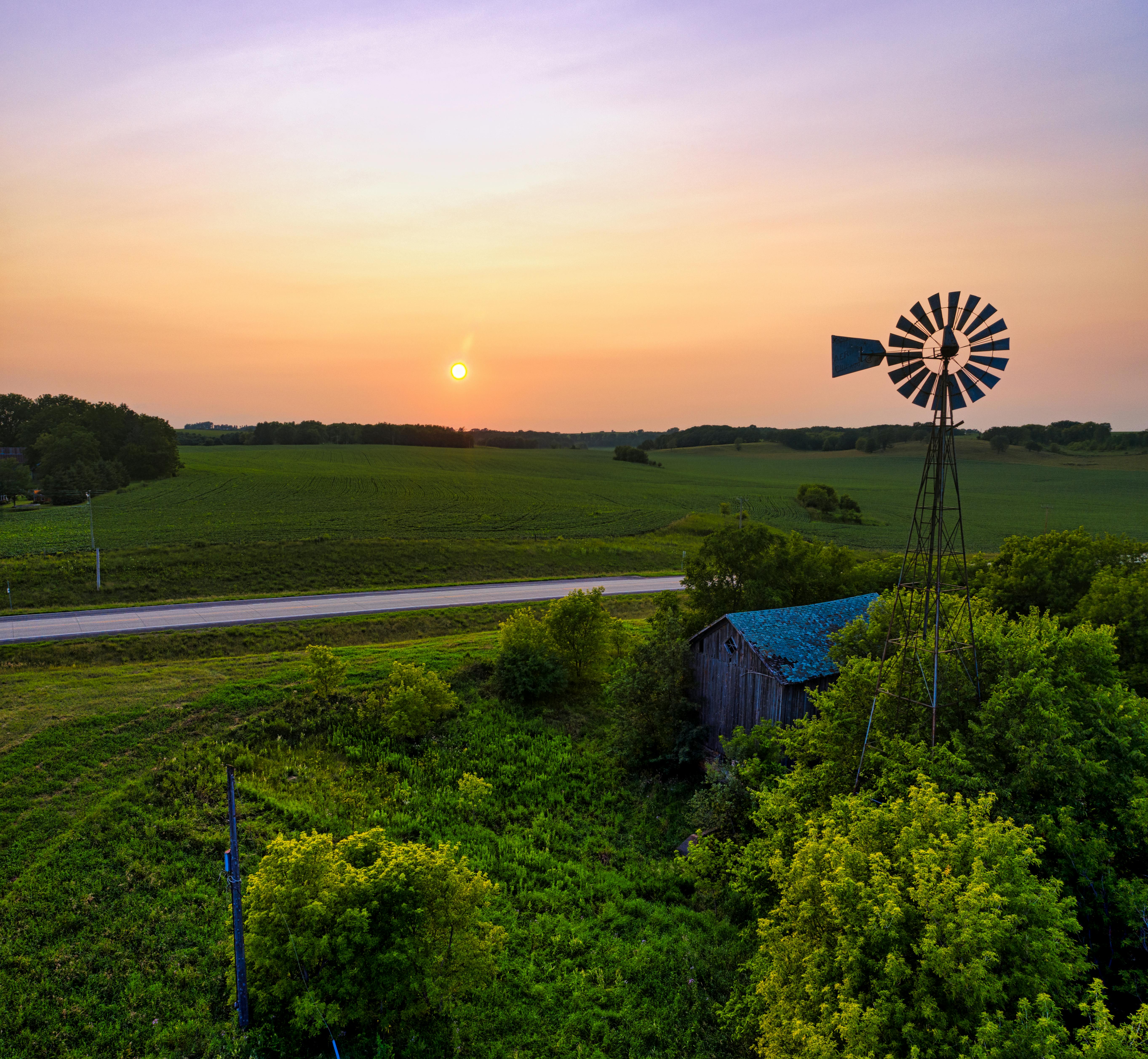 Captivating view of a windmill during sunset over a lush rural landscape in Minnesota.