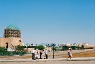 A family explores the historical landmarks in Turkistan on a sunny day, capturing cultural heritage and scenic views.