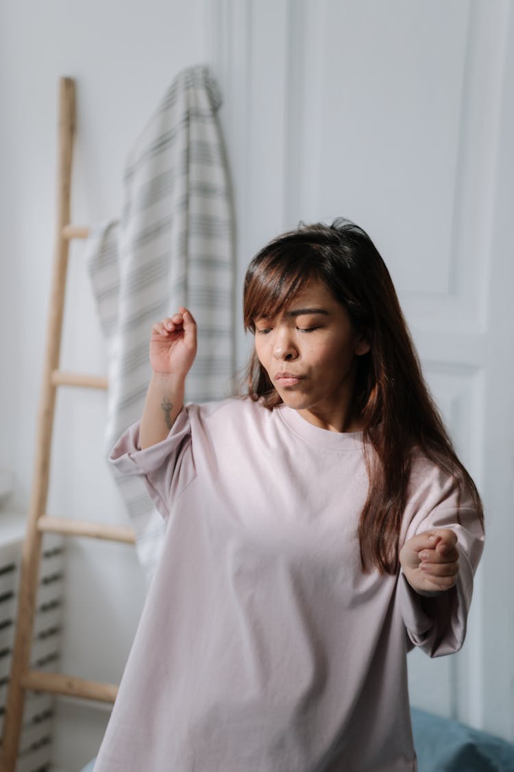 Young Dwarf Woman Listening To Music And Dancing In Her Bedroom