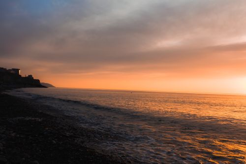 Free A serene sunset view over the ocean captures the tranquil beauty of nature with vivid colors. Stock Photo
