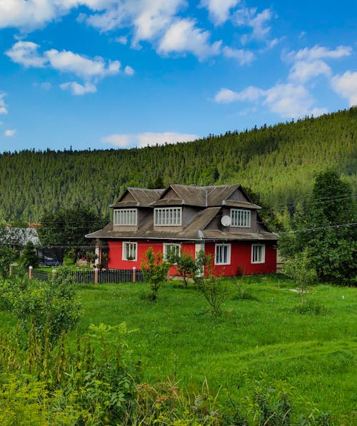 Photograph of a Red Wooden House on a Rural Area