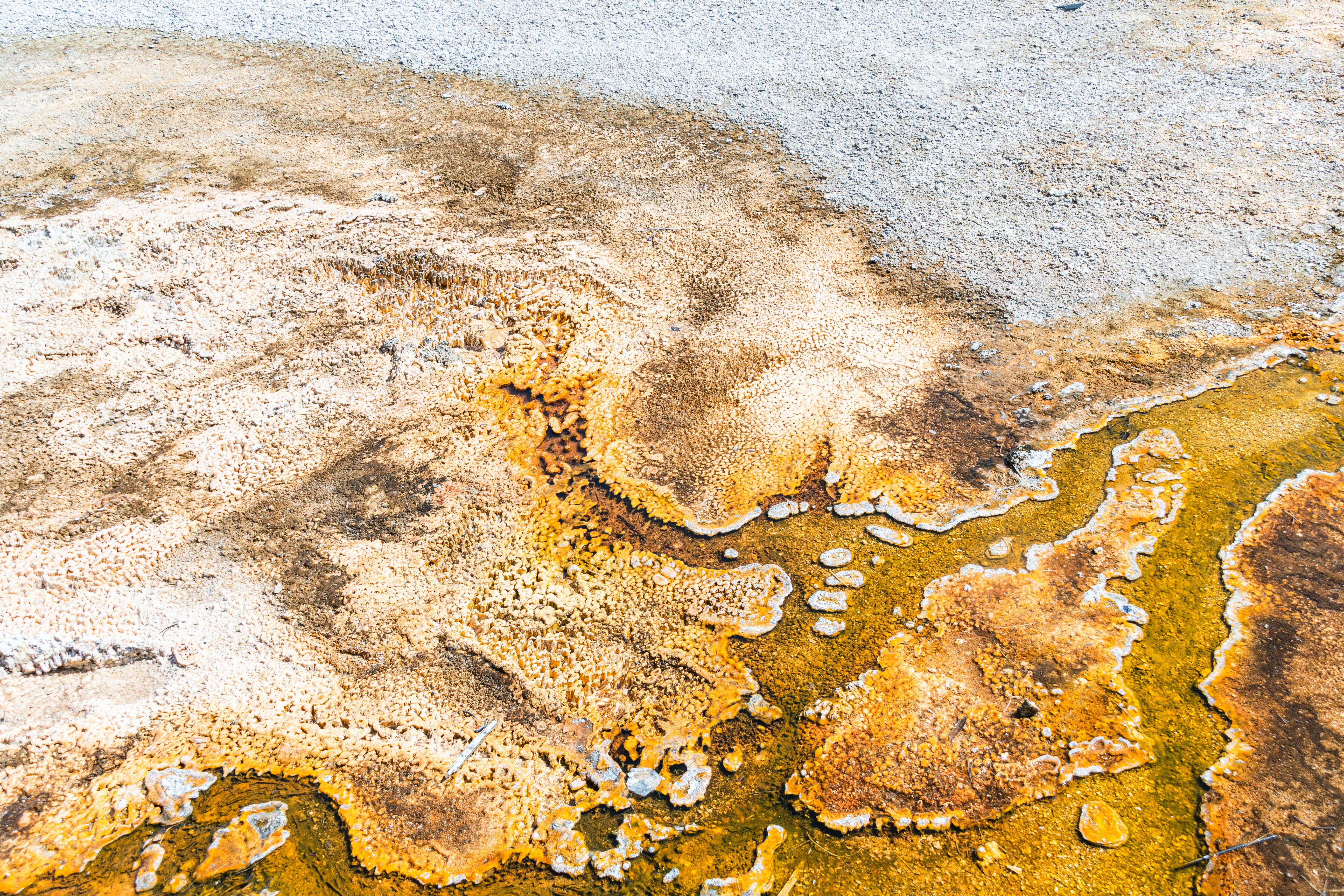 Aerial shot showing the natural colors and textures of a geothermal hot spring area.