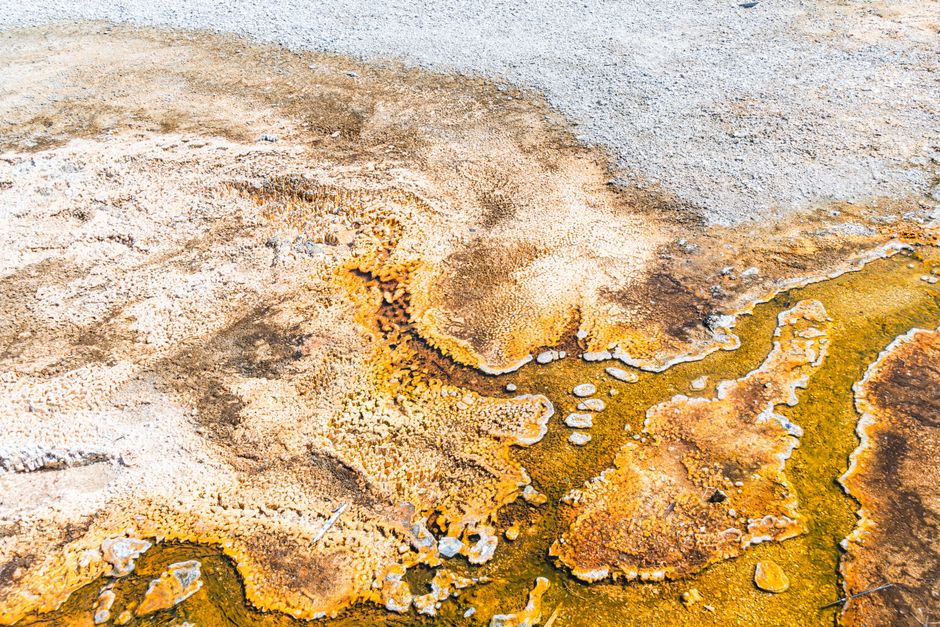 Aerial shot showing the natural colors and textures of a geothermal hot spring area.