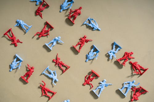 Red and Blue Plastic Toy Soldiers on Brown Surface