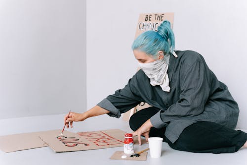 A Woman with Blue Hair Making a Poster 