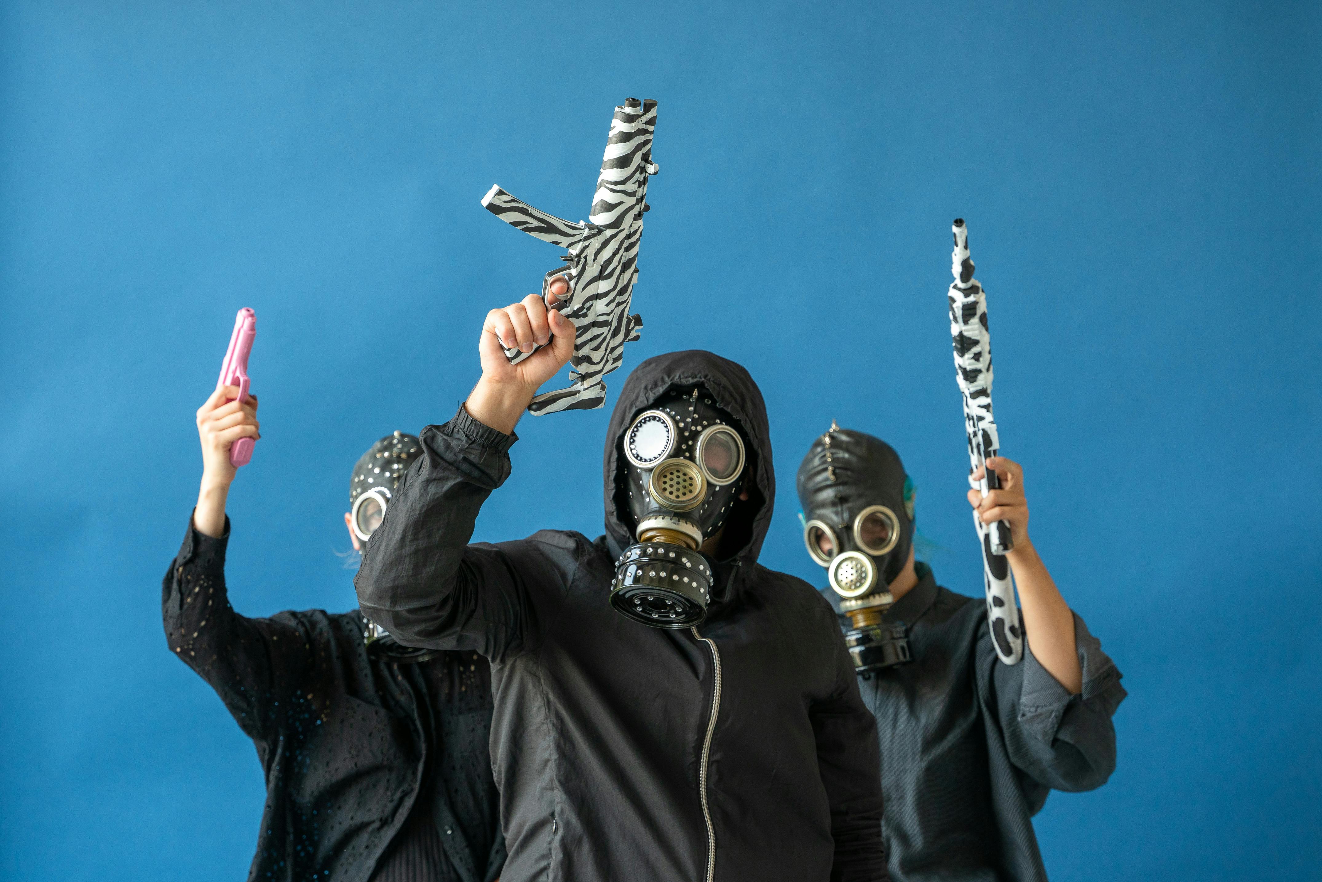 men in gas mask holding toy guns