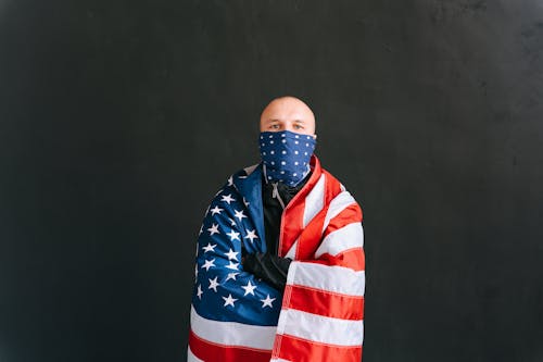 Photograph of a Man with a United States of America Flag Crossing His Arms