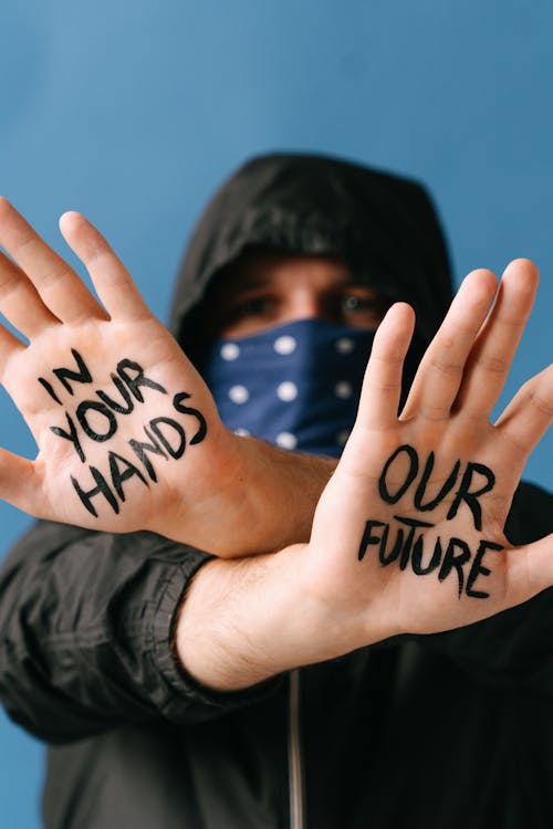 Man in Black Hoodie with Writing on Hands
