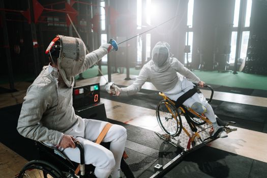 Dynamic wheelchair fencing match showcasing skill and determination indoors.