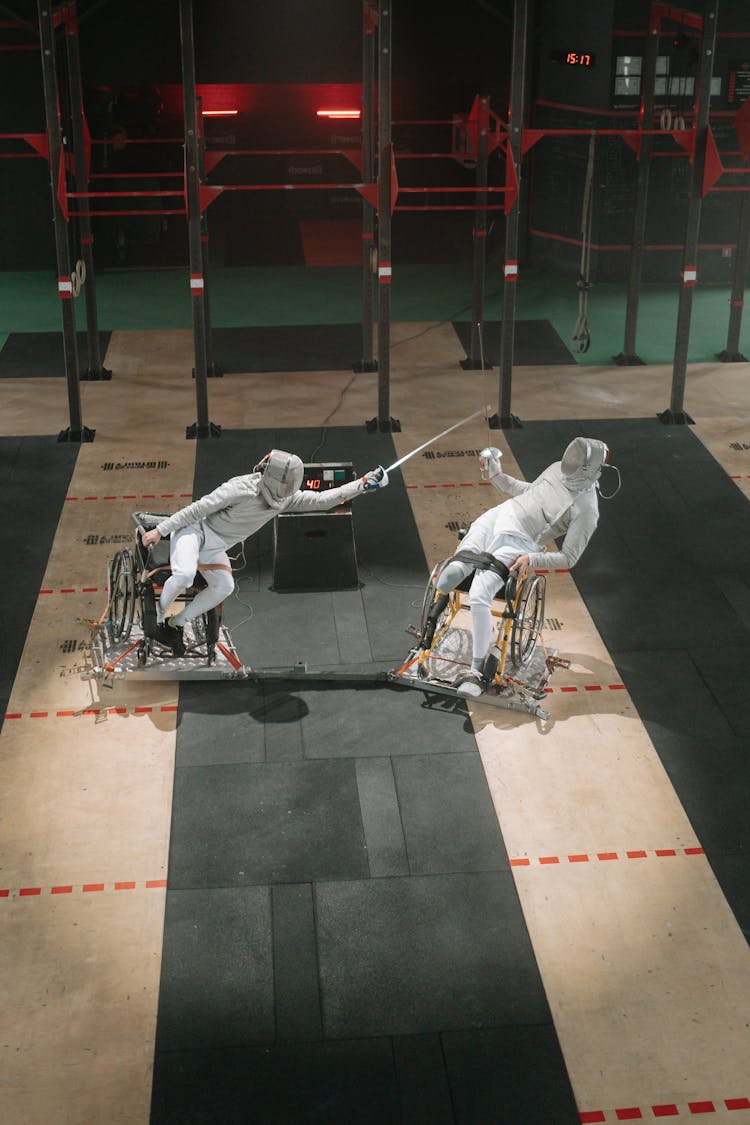 People In White Clothes Competing While Wearing Fencing Mask