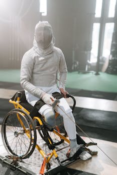 Paralympic athlete in a fencing match indoors, with focus on safety gear.