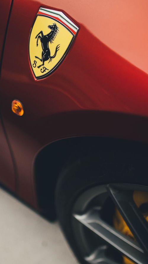 Free Close-up of a red sports car showcasing its iconic logo and sleek design. Stock Photo