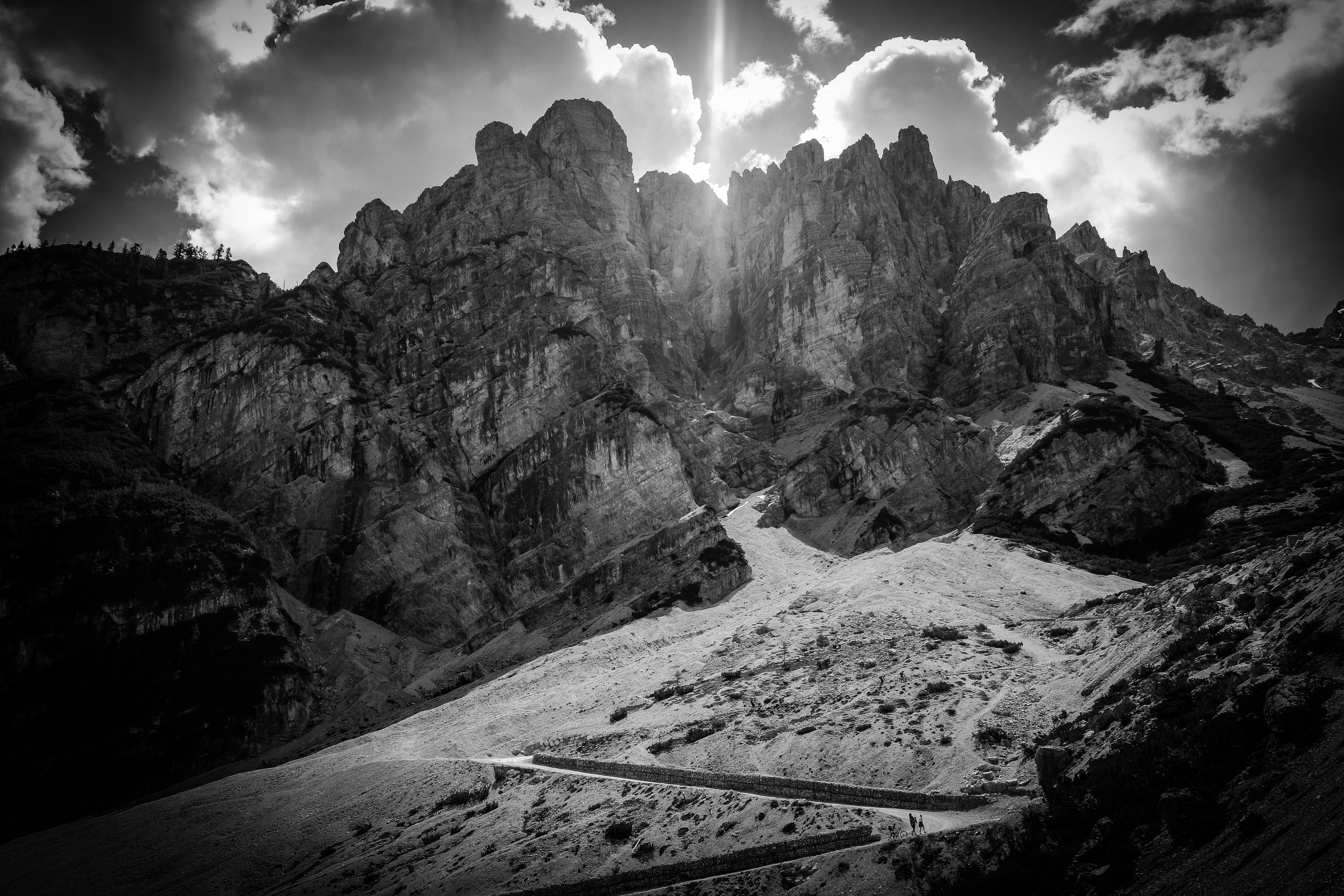 Striking black and white photo of rocky mountains under dramatic clouds.