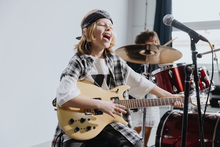 Photo Of A Kid Playing An Electric Guitar