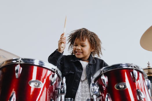 Photograph of a Child with Curly Hair Playing the Drums