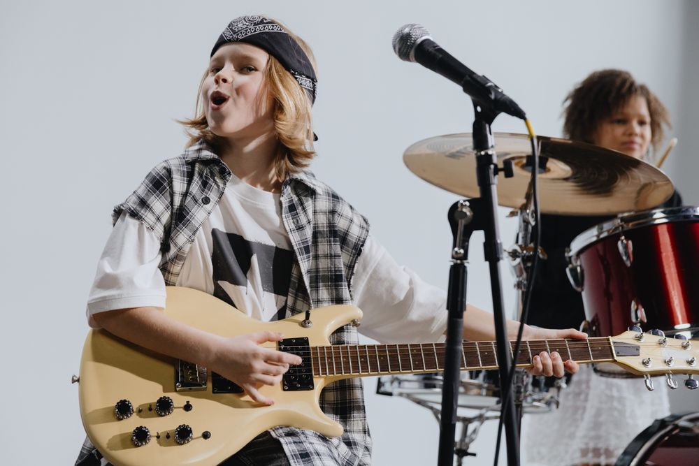 Des enfants qui jouent de la musique (guitare et chant)