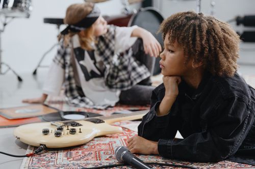 Free Two children engaging with musical instruments in an indoor setting, reflecting on music and creativity. Stock Photo