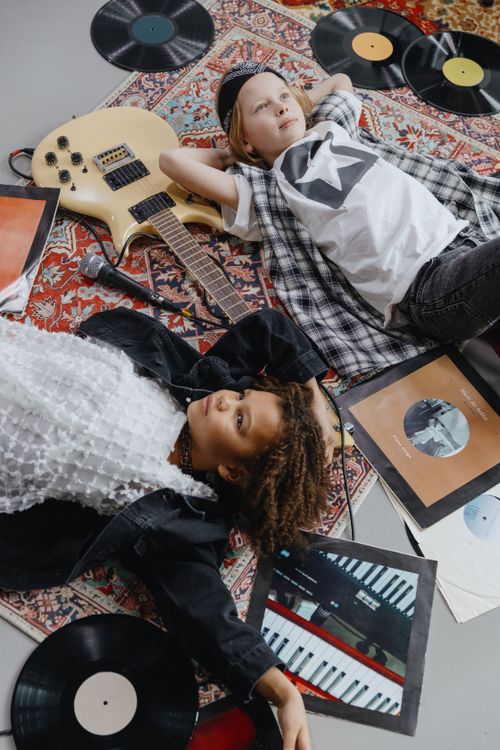 Free Two children enjoy a musical moment among vinyl records and a guitar. Stock Photo
