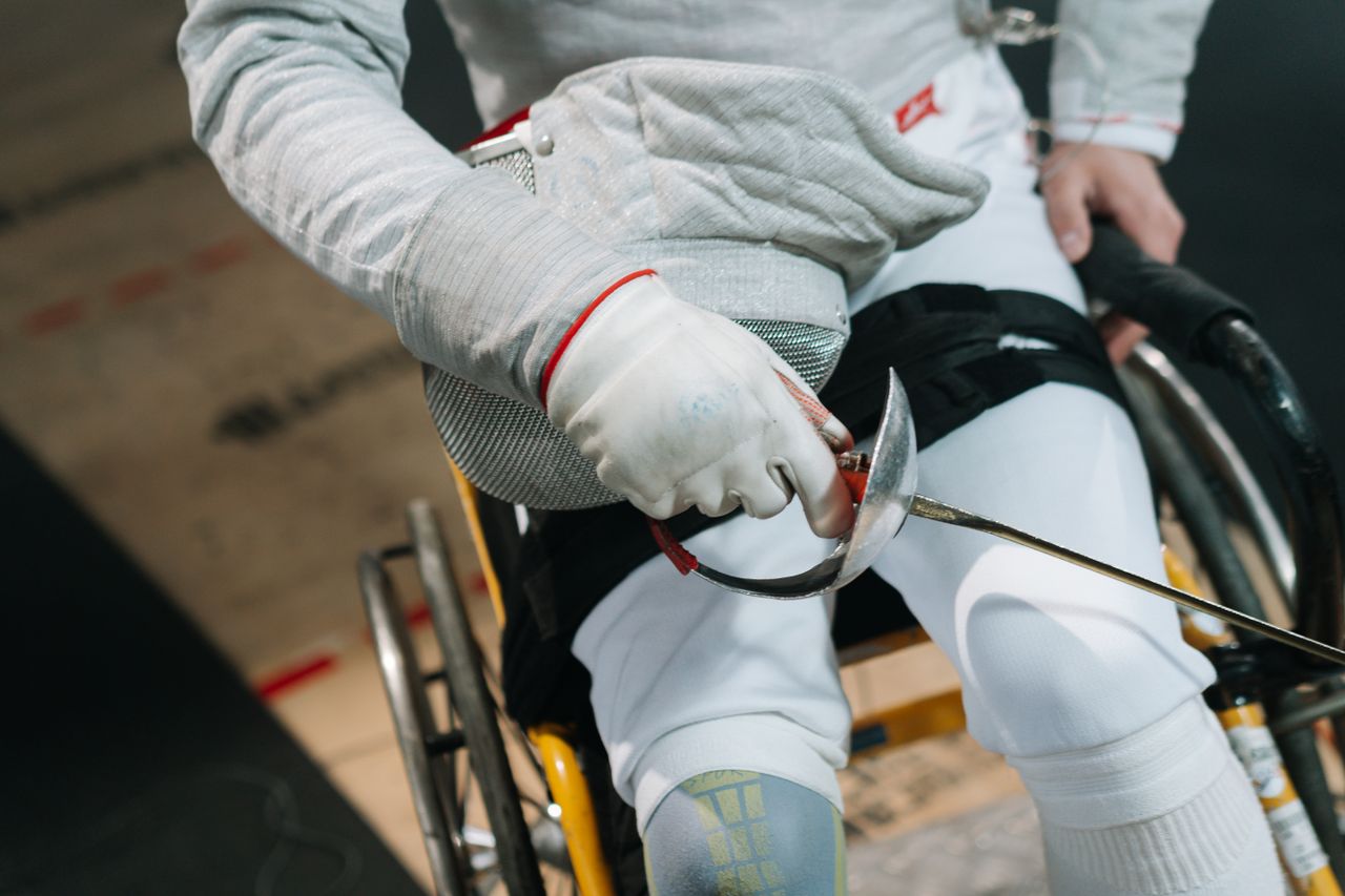 close up of a wheelchair fencer gripping a sabre showcasing focus and