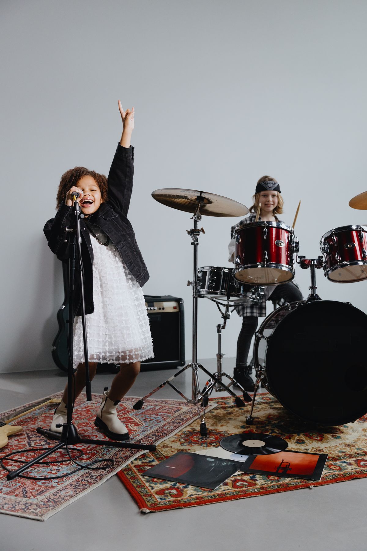 Kids performing together with drums and a microphone