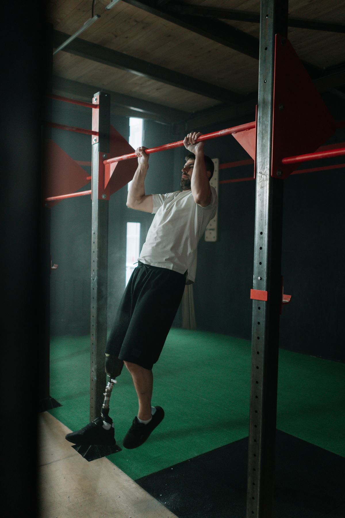 Man doing pull ups in a gym demonstrating progressive bodyweight exercise