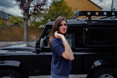 A Woman in Blue Shirt Standing Beside Black Jeep