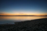 宁静的海滩上，日落静谧，海水平静，非常适合放松