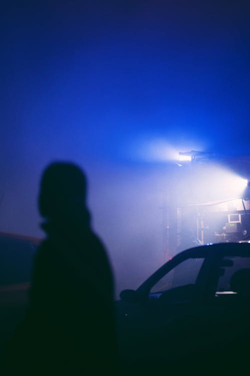 Silhouette of Person near Car in Darkness