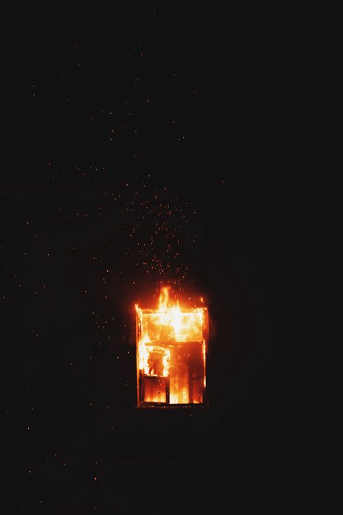 Free Dramatic image of a window engulfed in flames against a dark night backdrop. Stock Photo
