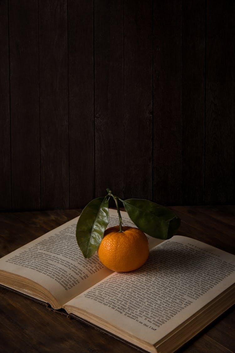 Photo Of Orange On Top Of Book