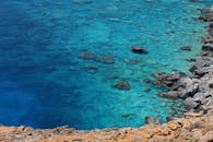 鸟瞰图中，清晰的蓝色海洋和岩石海岸线展现了原始的自然美景