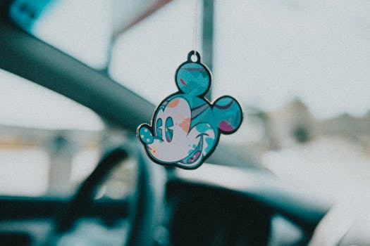 Close-up of a vibrant Mickey Mouse keychain hanging inside a car for a whimsical touch.