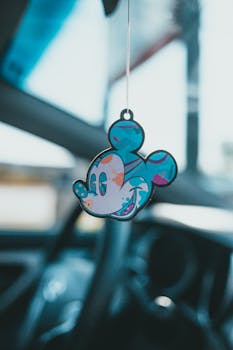 Close-up of a vibrant cartoon keychain hanging inside a car.