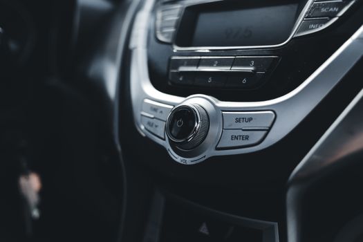 Detailed shot of sleek and elegant car stereo and AC controls.