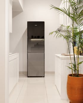 Stylish kitchen featuring a modern refrigerator and a decorative plant in a clay pot.