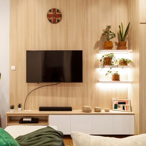 Living room with wooden wall shelves, plants and low storage — photo by Hakim Santoso on Pexels
