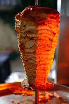 Mouthwatering shawarma meat cooking on a vertical rotisserie.