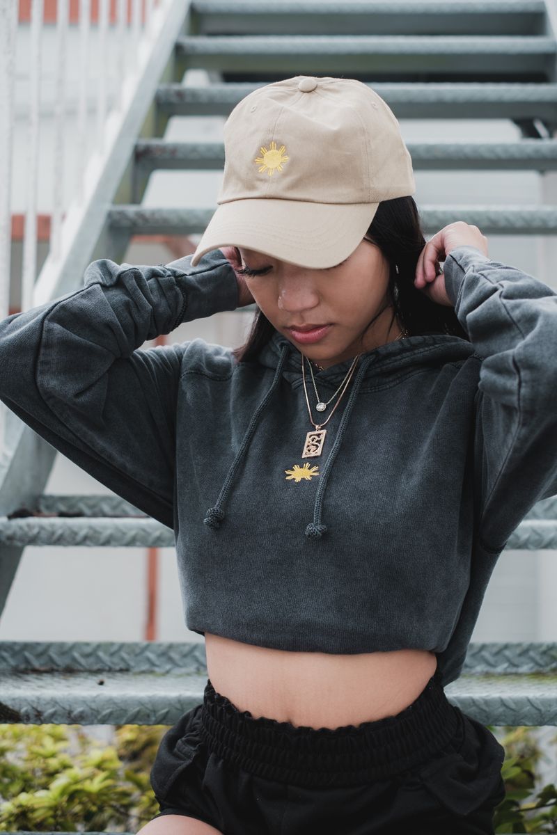 Young woman in a gray hoodie sitting on metal stairs